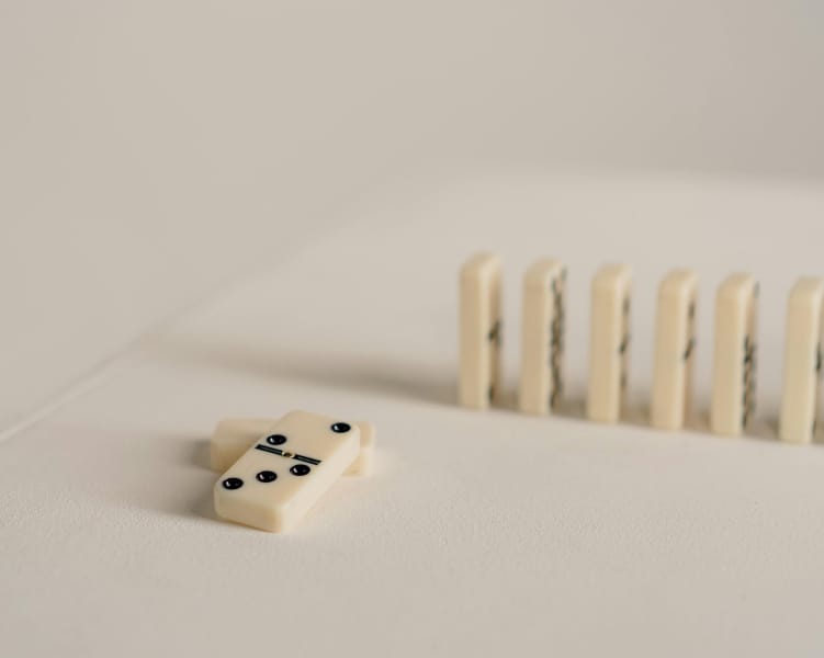 Dominoes lined up with one fallen piece